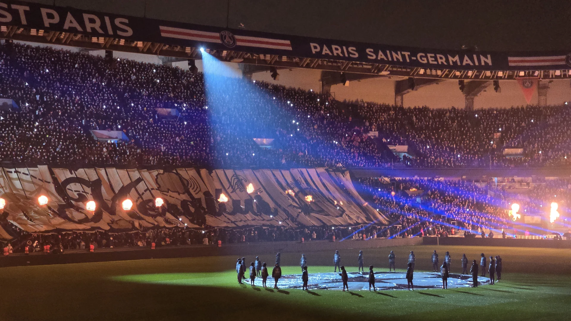 Le Parc des Princes illuminé avant PSG–Manchester City en janvier 2025, joueurs rassemblés sur la pelouse.